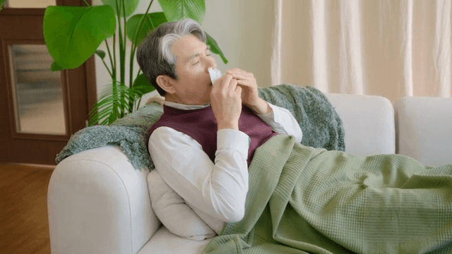 소파에 누워 기침을 하는 노인
