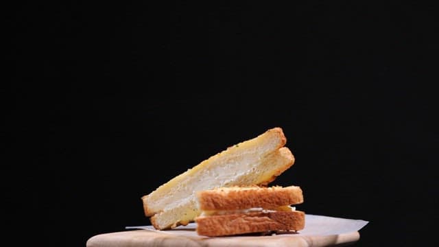 나무 도마 위의 생크림이 들어간 마늘토스트 조각