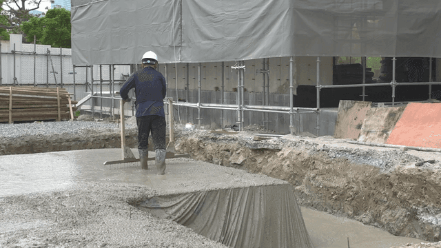 Workers smoothing concrete at a construction site