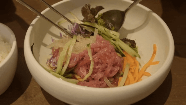 Mixing Beef Tartare Bibimbap with vegetables