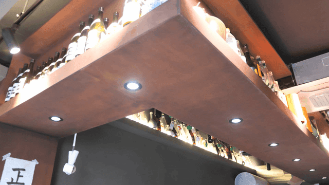 Shelf with various bottles at bar