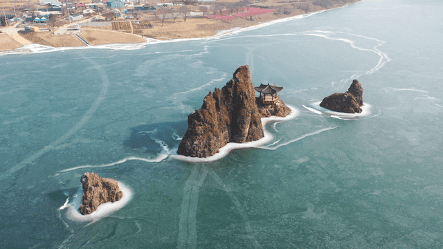 Frozen lake with rocky islets and pavilion