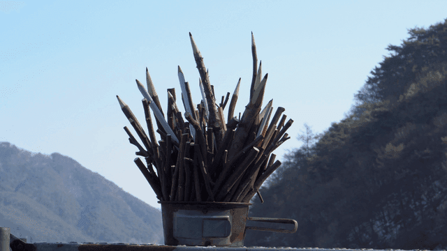 산 배경의 나뭇가지 연필 조각품