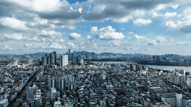 Panoramic view of city spread out under cloudy sky