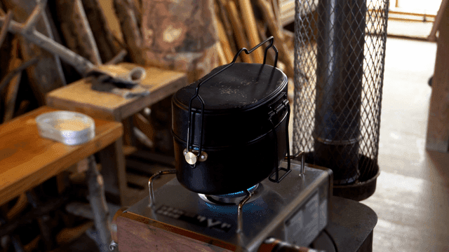 작업실에서 가스버너 위로 물이 끓고 있는 반합