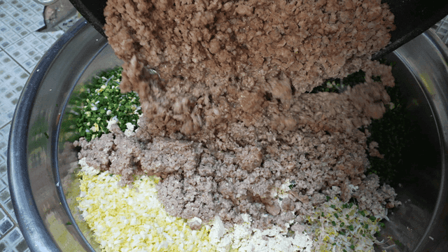 Minced meat poured into bowl of vegetables
