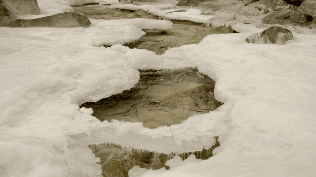 Frozen river with flowing water