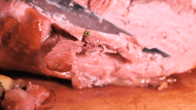 Cutting juicy roast turkey leg