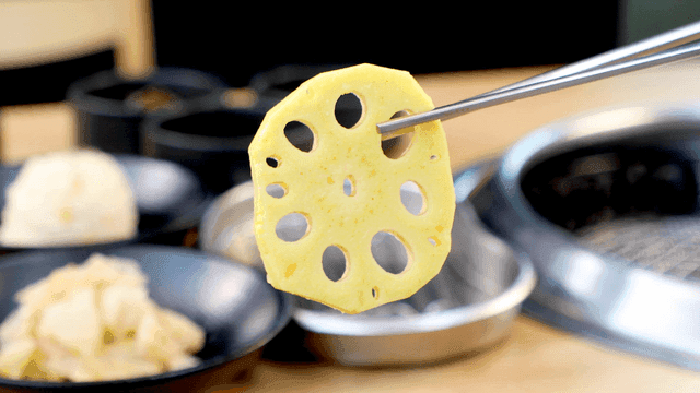 Lotus root slice held with chopsticks