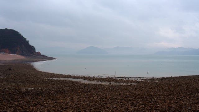 Rocky beach on a cloudy day with clouds and fog