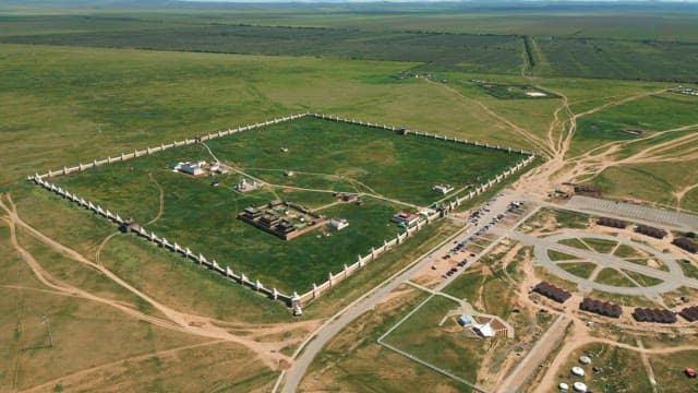 Vast green landscape with a historic temple