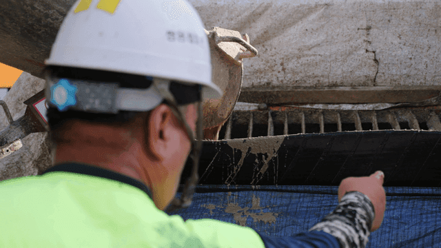 Worker overseeing concrete pouring
