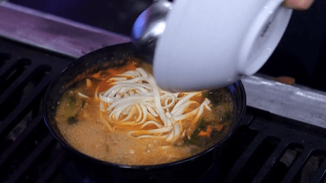 매운 칼국수 국물에 면을 추가하는 모습