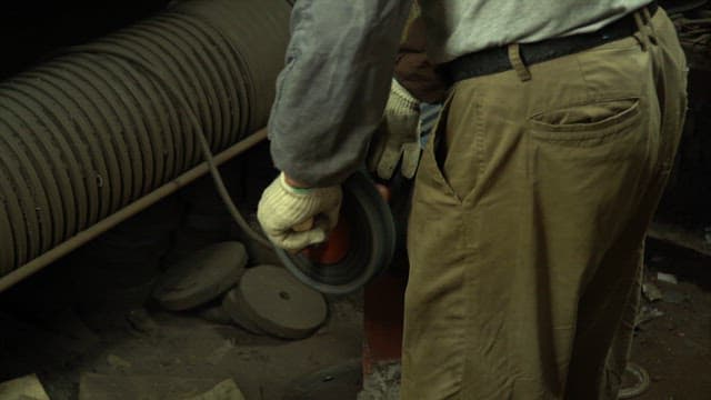 Worker operating a grinding machine