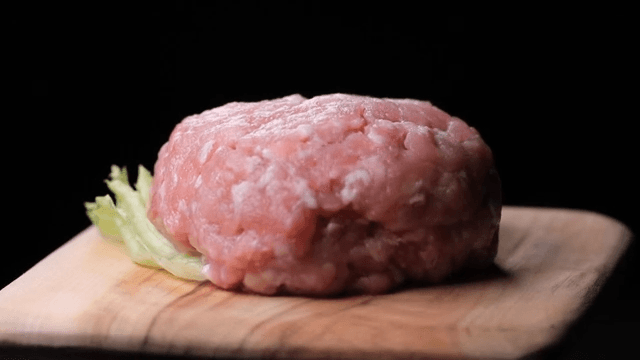 나무 도마 위의 생돼지고기 패티