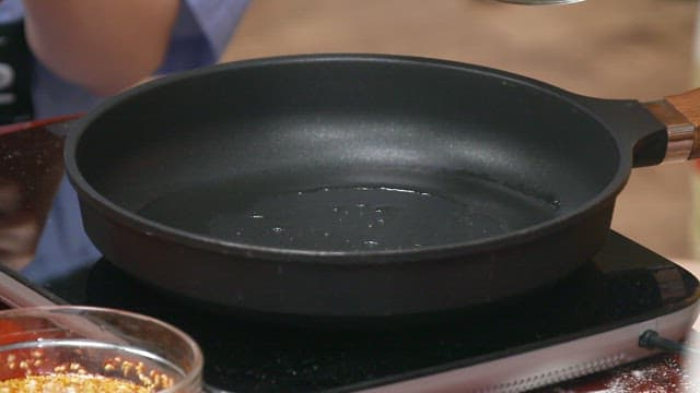 Putting the dried radish greens pancake batter on a heated frying pan