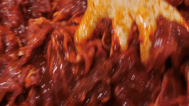 양념된 고기를 그릇에서 섞는 모습