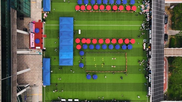 빨갛고 파란 파라솔이 있는 행사장에 모인 사람들