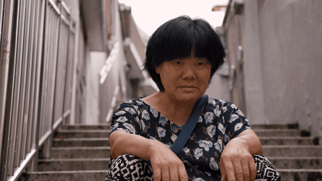 계단에 앉아 있는 노인 여성