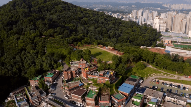 푸른 산과 건물이 있는 도시 풍경