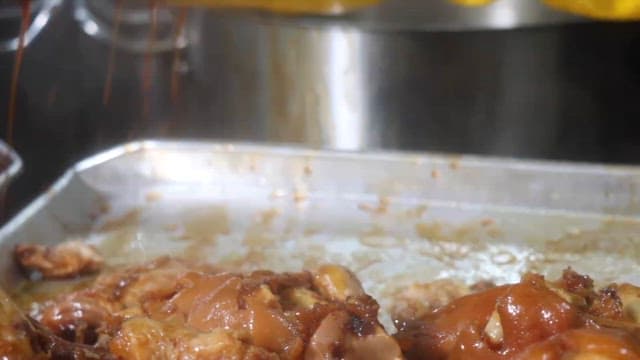 Cooking process of simmered pig's feet with gloved hands