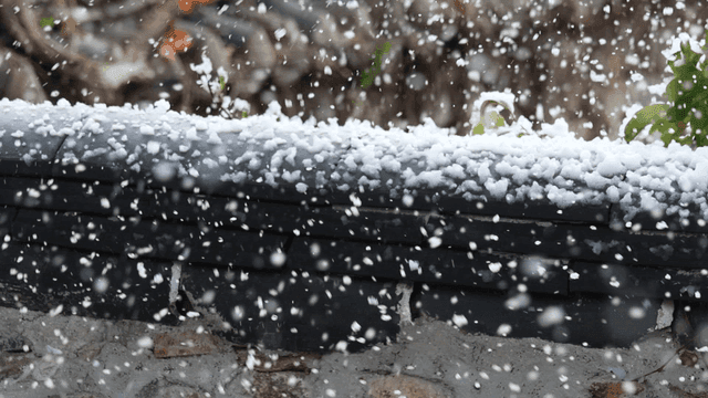 Snowflakes falling on a stone wall