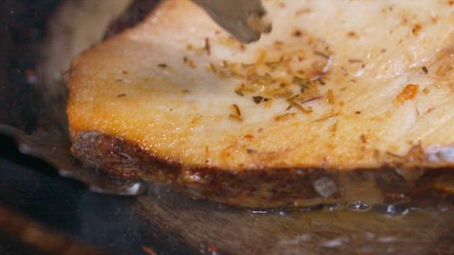 프라이팬에서 뜨거운 기름으로 조리하는 참치 스테이크