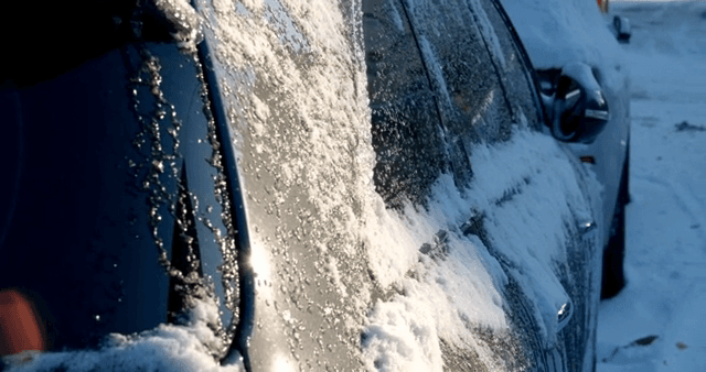 Snow-covered car in a winter setting