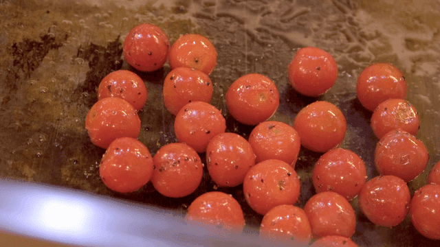 Cherry tomatoes being cooked on a grill