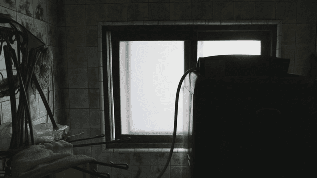 Dimly lit laundry room with a window