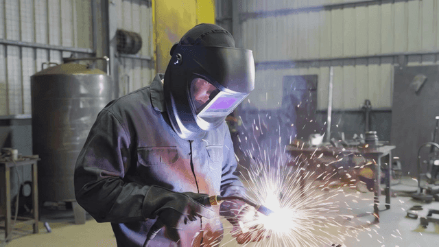 Worker welding in factory