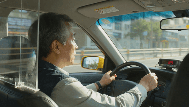 도심 거리를 운전하는 택시 기사