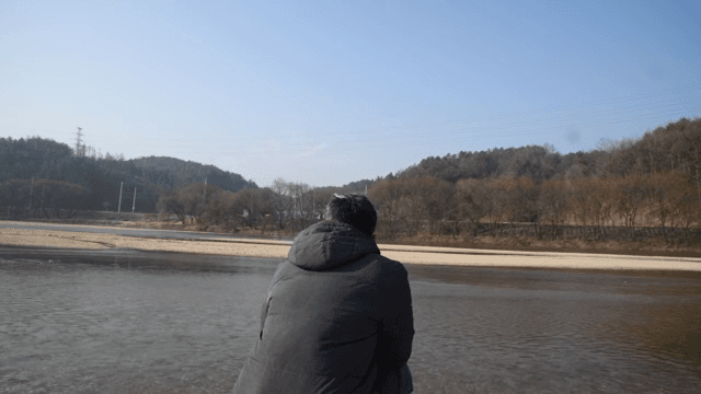 고요한 강가에 앉아 있는 사람