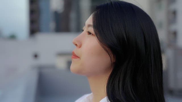 발코니에서 도시를 바라보는 여성