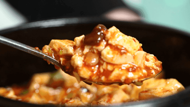 Spicy Mapo Tofu scooped out with spoon