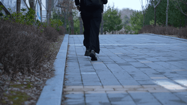 Back of woman running along park path