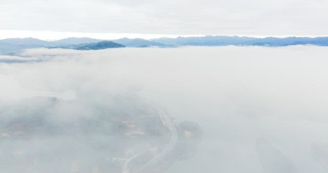 Misty Lakeside Road Amidst Forested Hills