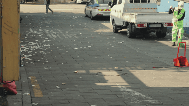 바쁜 인도를 쓸고 있는 거리 청소부 