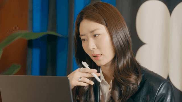 Woman with a satisfied expression looking at her laptop