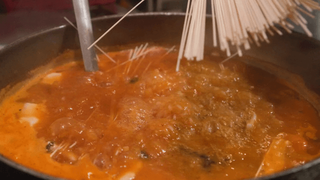 끓고 있는 어죽에 소면을 추가하는 사람