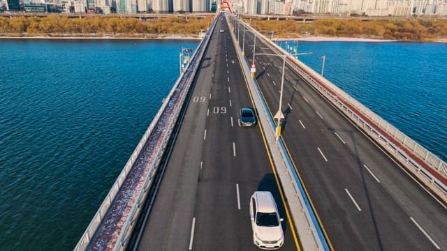 Vehicles Passing by the Bridge over the Calm Han River