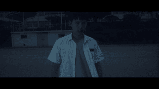 어두운 학교 운동장을 걸어 나오는 화가 난 학생