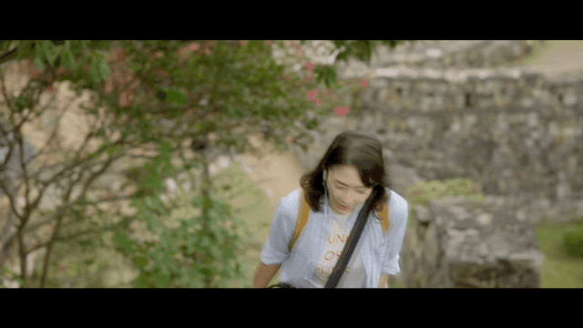 Woman climbing old castle wall