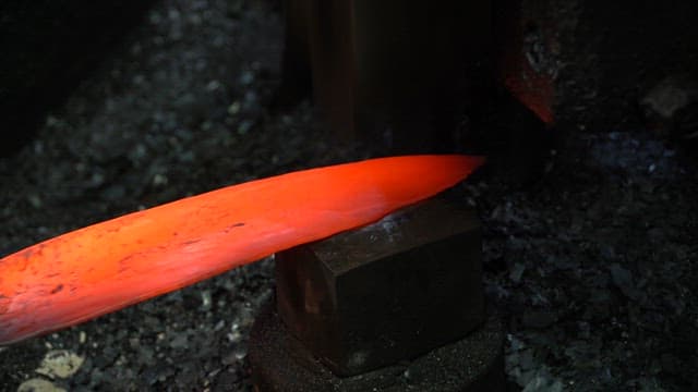 Heated metal blade being forged