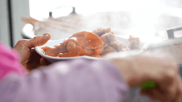 Grandmother at snack shop who piles tteokbokki high on gimbap rolls