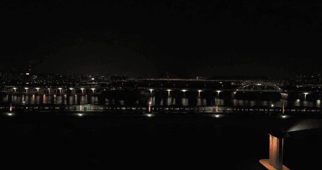 Night view of a city with a train crossing a bridge