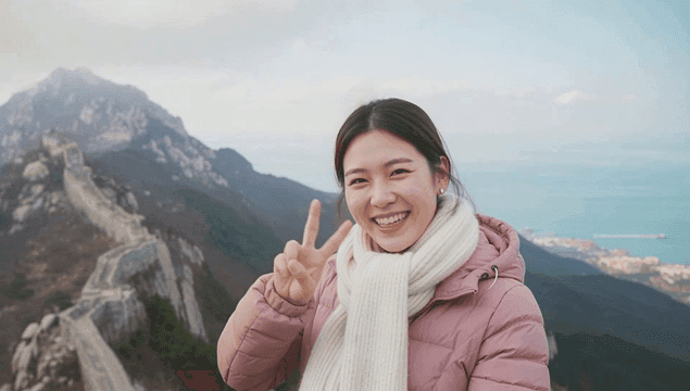 겨울 산 정상에서 포즈를 취하는 미소 짓는 여성