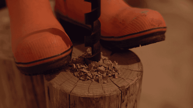 주황색 부츠를 신고 나무에 드릴 작업