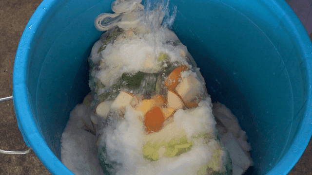 Water poured into vegetables and salt in blue container