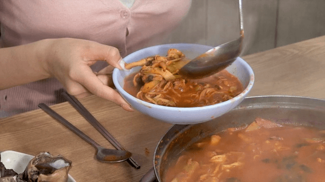 매운 한국 찌개를 그릇에 담는 모습